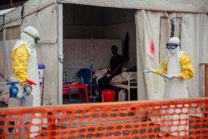 Un soignant en combinaison de protection devant un centre de traitement à Bunia (AP)