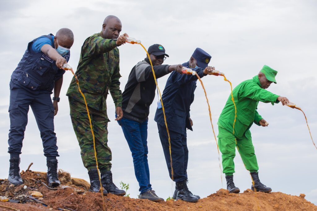 Des responsables des services de sécurité et d’autres autorités détruisent des boissons alcoolisées illicites à Nduba, dans le district de Gasabo. Plus de 27 500 litres avaient été détruits lors de cette opération. Photo : Rwanda National Police.